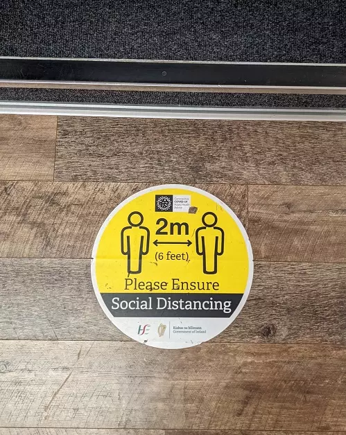 covid social distancing sticker at foot of staircase