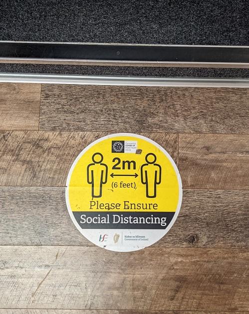 covid social distancing sticker at foot of staircase