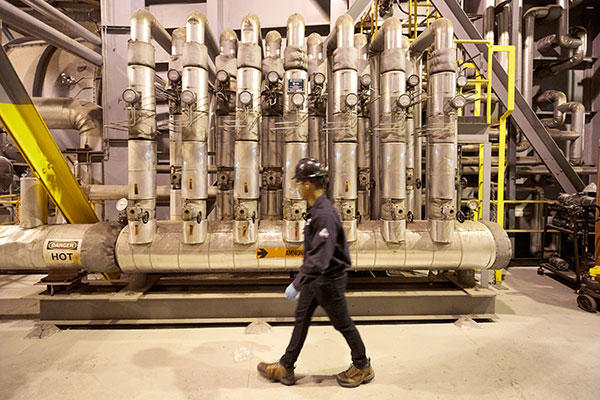 Employee from the staff walking inside an industrial site for energy production.